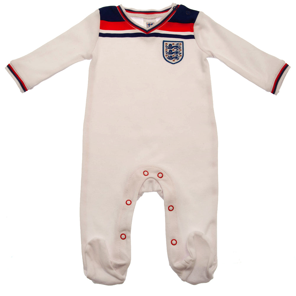 This long sleeved baby sleepsuit features England's traditional white home colours, Design inspired by the 1982 world cup kit with an embroidered crest 