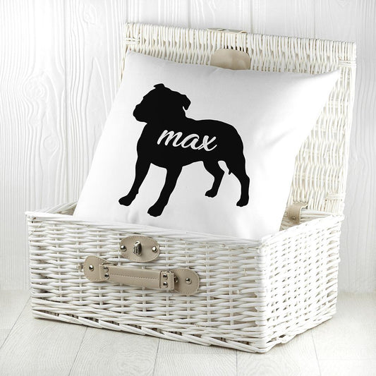 White cushion with black silhouette of a staffordshire bull terrier personalised with name photographed inside a white wicker basket  By Sweetlea Gifts